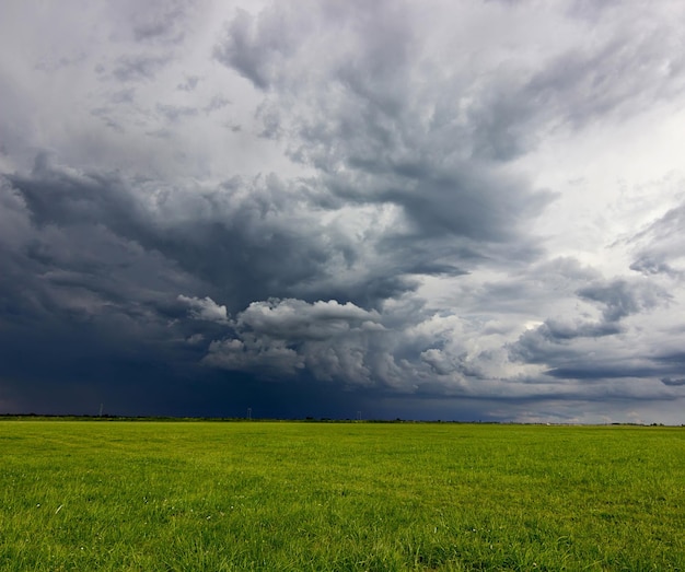 Photo nuages d'orage supercellulaires au-dessus d'un pré avec de l'herbe verte nuages d'orage d'été