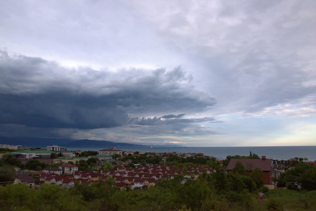 Les nuages de pluie se rassemblent sur la ville avant un orageVue de la ville depuis la hauteur des montagnes Mer Noire Myskhako Novorossiysk Russie