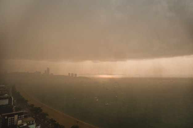 Nuages pluvieux de forte tempête au-dessus de la ville moderne au bord de la mer