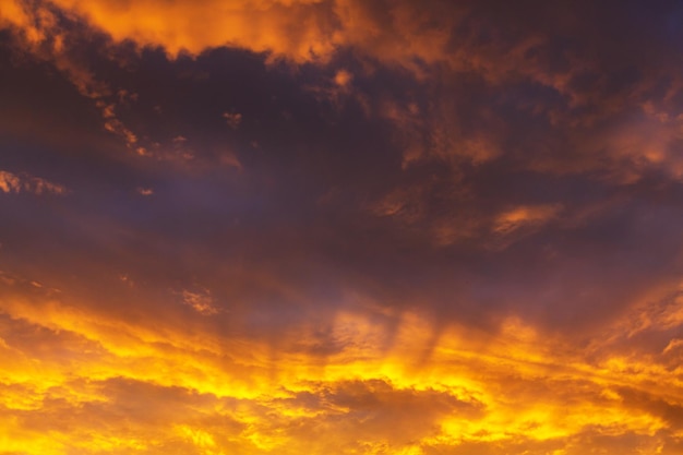 Nuages de tempête inhabituels au coucher du soleil. Couleurs rouge vif et orange du ciel. Convient pour le fond.