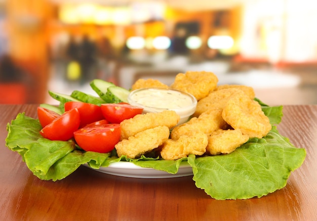 Nuggets de poulet frit avec légumes et sauce sur table au café