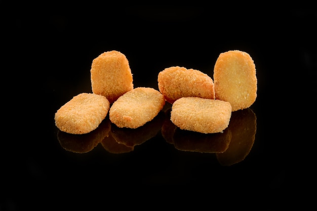 Nuggets de poulet de restauration rapide avec du ketchup, sur un fond sombre