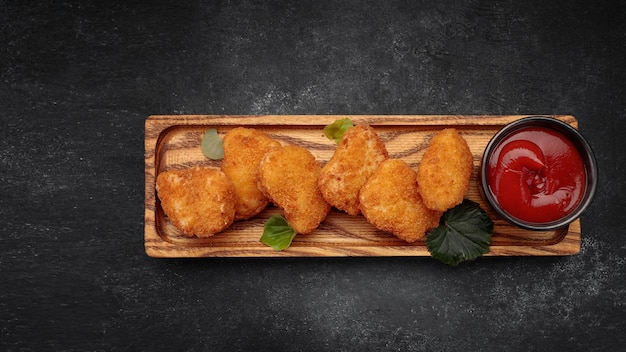 Nuggets de viande avec du ketchup sur fond sombre