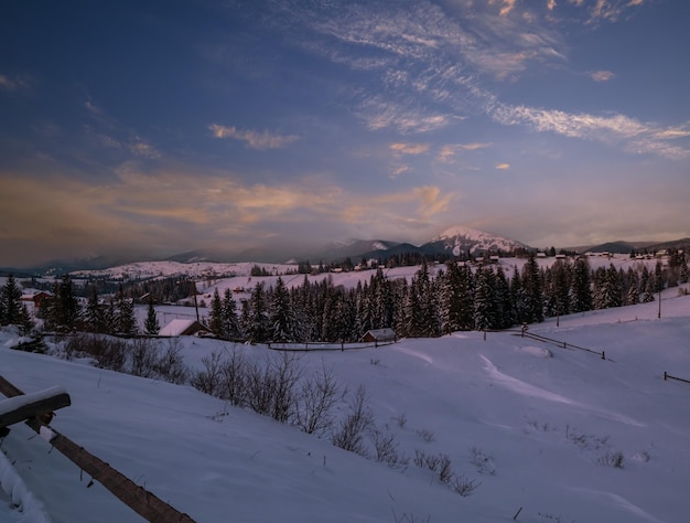 Photo la nuit, la campagne, les collines, les bosquets et les terres agricoles en hiver, le village alpin isolé de l'ukraine, voronenko