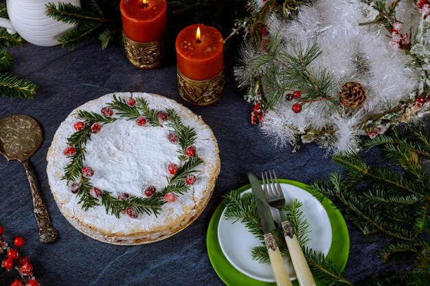 Nuit de Noël avec un gâteau de fête décoré de branches de canneberge et de pin