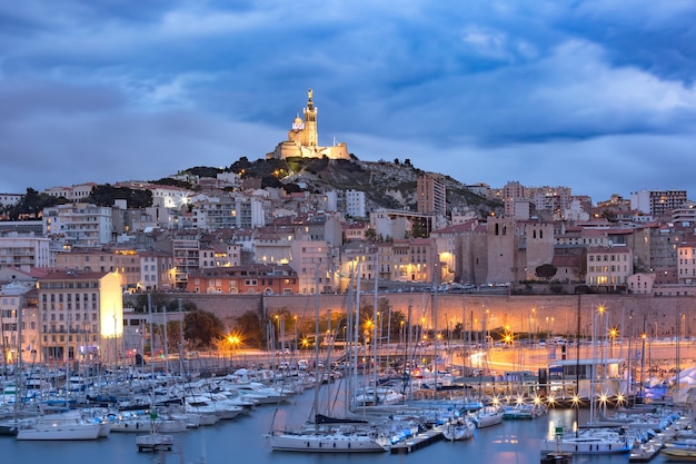 Nuit Vieux Port et la Basilique Notre Dame de la Garde en arrière-plan, sur la colline, Marseille, France