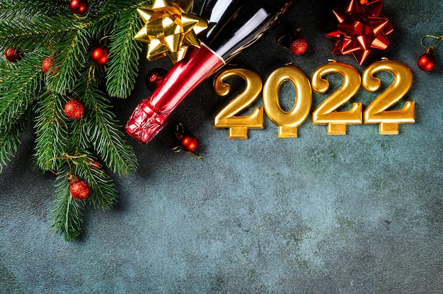 Numéro 2022 avec bouteille de champagne et décor. Bonne année et concept festif. Vue horizontale supérieure, copyspace. Nouvel An à plat. Appartement de Noël. Nouvel an 2022. Concept de nouvel an.