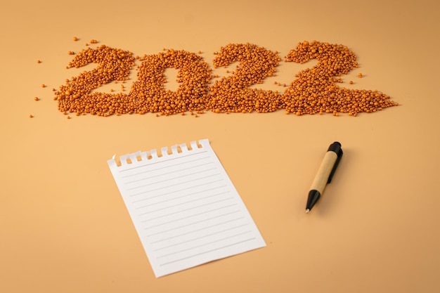 Numéro 2022 à côté d'un cahier et d'un stylo de planification La figurine est en orange vif brillant