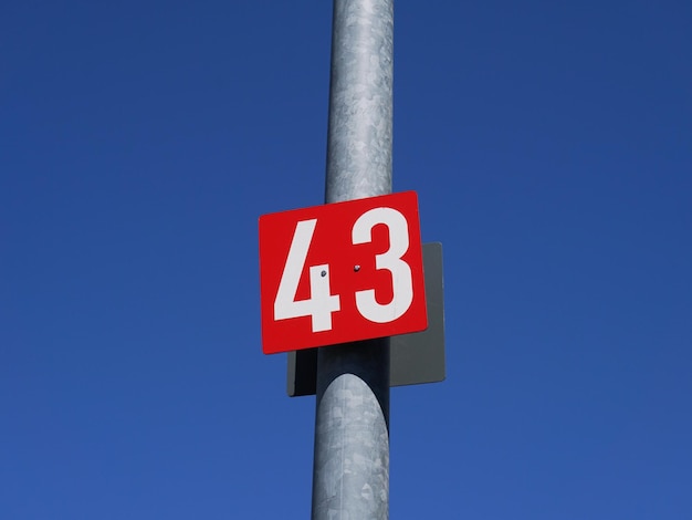 Numéro 43 sur une affiche rouge sur le poteau métallique