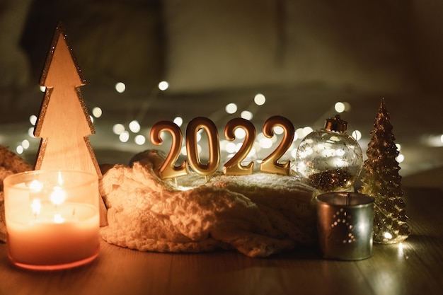 Numéro de bonne année fait par des bougies sur un fond de bokeh scintillant festif dans l'obscurité