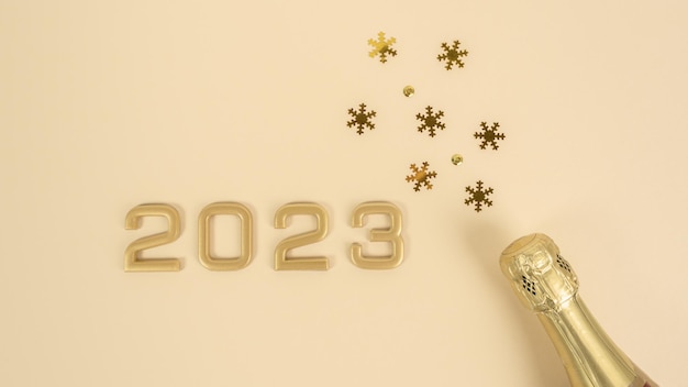 Numéros 2023 et bouteille de champagne avec confettis. Célébration ou fête du Nouvel An
