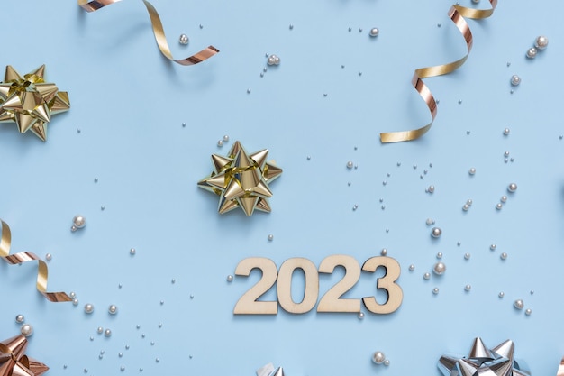 Numéros 2023 sur fond festif lumineux avec des arcs et des perles vue de dessus fond de Noël mise à plat