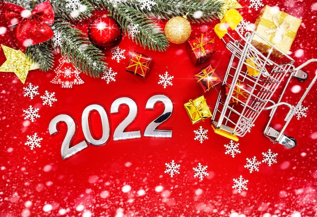 numéros d'argent 2022 sur fond rouge avec des décorations de Noël et des flocons de neige