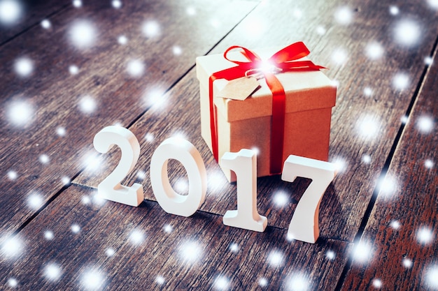Numéros en bois formant le numéro 2017, Pour la nouvelle année et la neige sur bois rustique avec boîte cadeau et ruban rouge.