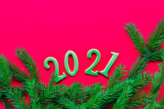 Numéros d'or et fond rouge solide de branche d'arbre de Noël vert. Nouvel an et Noël