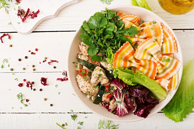 Nutrition adéquat. Salade diététique. Farfalle pâtes blé dur avec filet de poulet au four avec aubergine, courgettes et salade dans un bol. Vue de dessus. Mise à plat