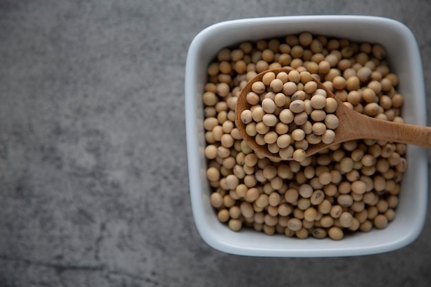 Photo nutrition des aliments crus de soja dans une cuillère en bois sur un bol