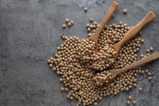 Photo nutrition des aliments crus de soja dans une cuillère en bois sur un tas