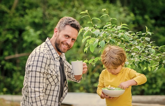 Photo nutrition enfants et adultes concept de nutrition saine menu pour enfants habitudes nutritionnelles la famille apprécie un repas fait maison un petit déjeuner sain père fils mangez et amusez-vous petit garçon et père mangent