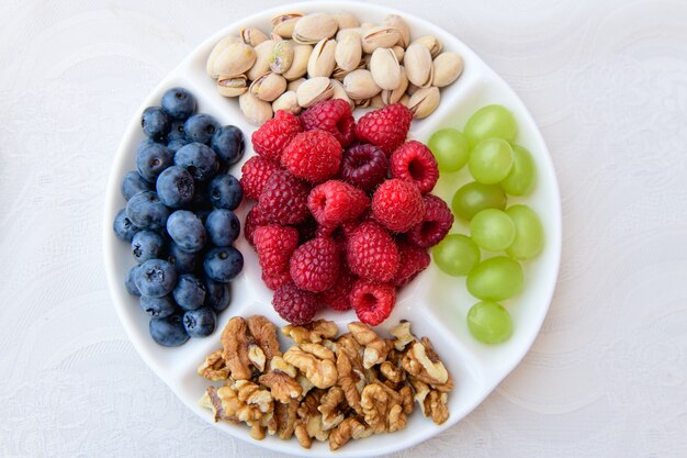 Nutrition saine, baies et noix. fraises des bois, raisins, bleuets, noix, pistaches. Concept de nourriture écologique. Baies et noix mélangées. Image libre de droits DSLR, option petit-déjeuner sain ou collation