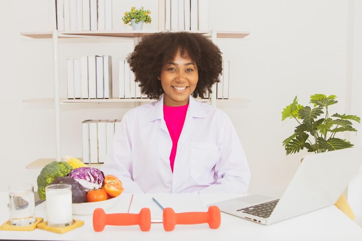 Photo une nutritionniste afro-américaine souriante assise dans le bureau d'un laboratoire médical