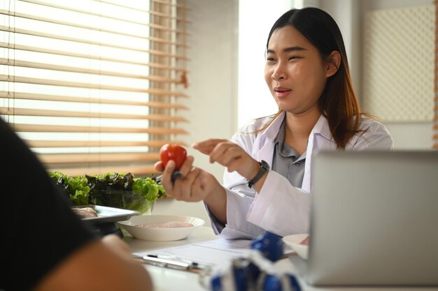 Une nutritionniste asiatique donne des consultations à un patient dans une clinique de perte de poids.