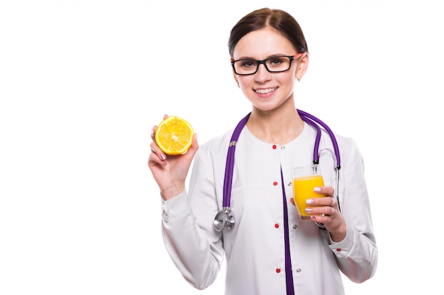 Nutritionniste femme tenir orange dans la section et un verre de jus de fruits frais dans ses mains sur le blanc