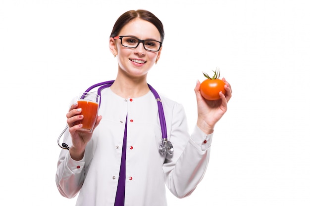 Nutritionniste femme tenir tomate dans la section et un verre de jus dans ses mains sur le blanc