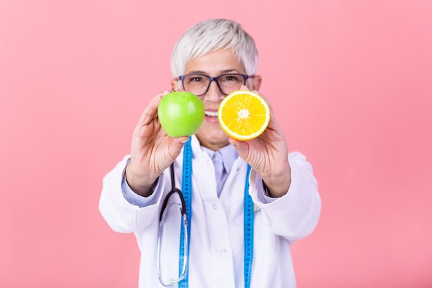 Nutritionniste avec fruits sains, jus et ruban à mesurer.