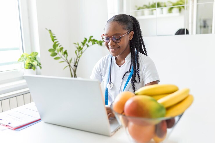 Photo nutritionniste souriante dans son bureau, elle montre des légumes et des fruits sains, des soins de santé et un concept d'alimentation.