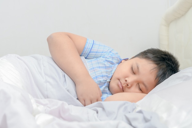 Obèse gros garçon dort sur le lit,