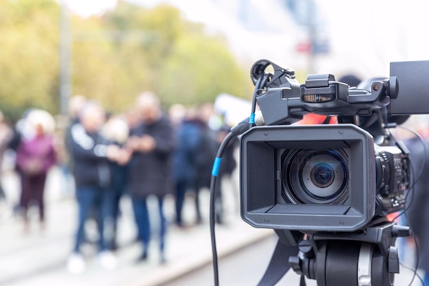 Photo l'objectif de la caméra de télévision dans le foyer brouille les gens à l'arrière-plan