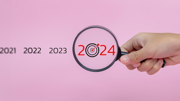 Photo objectif du concept d'entreprise magnificateur à la main axé sur l'année 2024 concentration sur les nouveaux objectifs d'entreprise plans et stratégies du concept de l'année 2024.