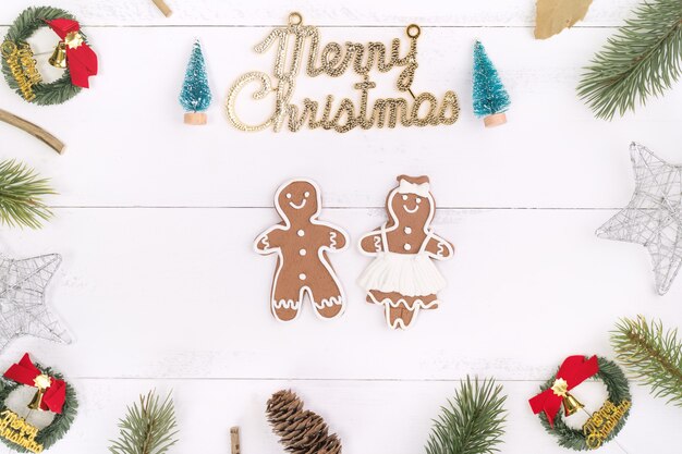 Objets de décoration de composition de concept de Noël, couronne de branche de sapin, biscuit d'homme en pain d'épice isolé sur une table en bois blanc, vue de dessus, mise à plat