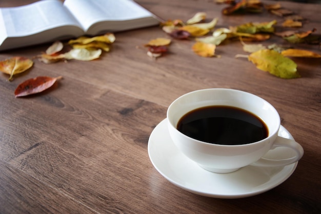 Objets sur une table en bois une tasse de café et un livre