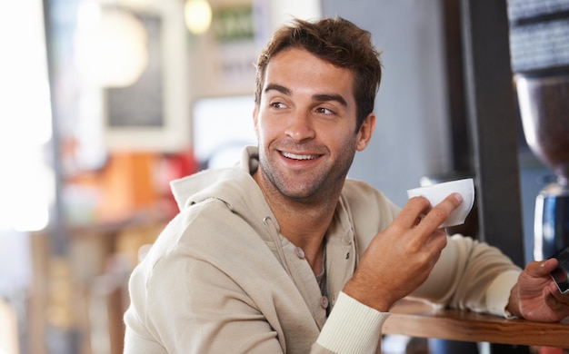 Obtenir ma dose quotidienne de café Photo d'un beau jeune homme buvant un café dans un café