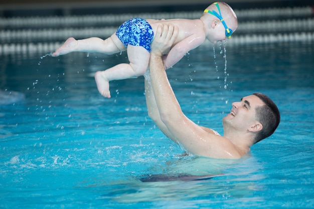 Occupation dans la piscine des enfants avec un entraîneur de natation.