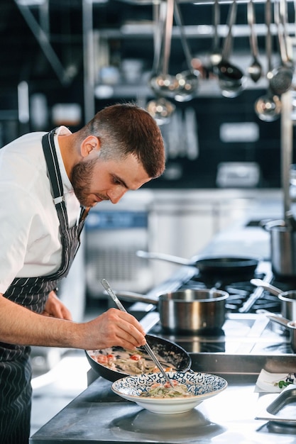 Photo occupé au travail le chef est dans la cuisine en train de préparer la nourriture