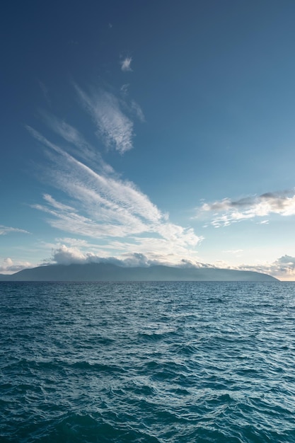 Océan bleu vif dans un ciel bleu nuageux avec des îles à l'horizon en albanie
