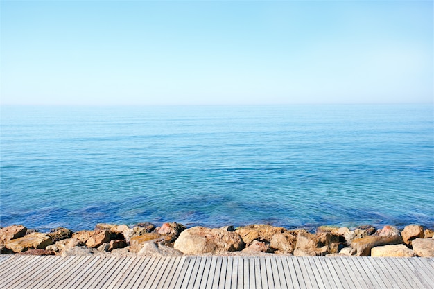 Photo océan, ciel bleu et plage. côte de mer et bureau en bois.