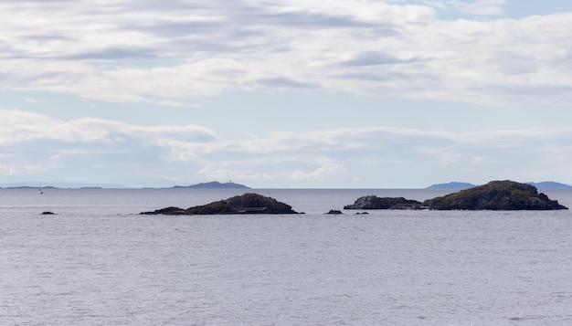 Océan et montagnes de l'île rocheuse par temps nuageux