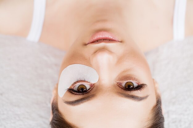 Oeil de femme avec de longs cils. Belle jeune femme pendant l'extension des cils