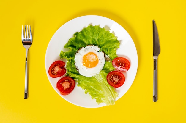 Photo oeuf ami laïque plat avec plat de légumes avec des couverts sur fond uni