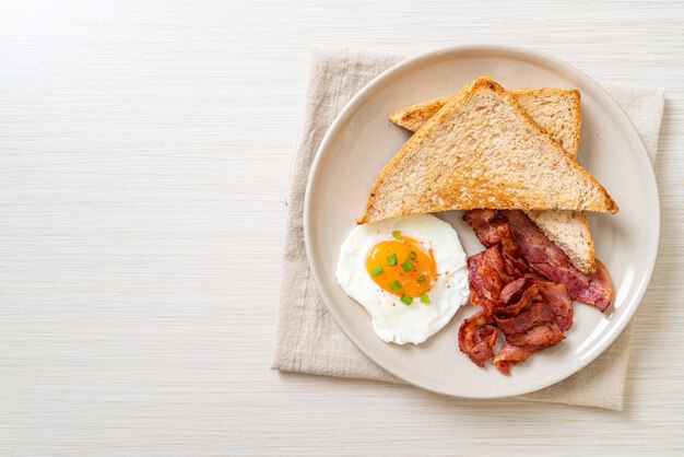 oeuf au plat avec du pain grillé et du bacon pour le petit déjeuner