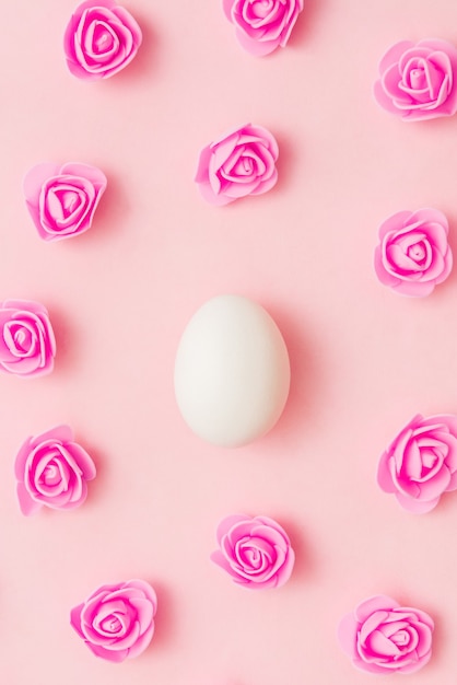 Oeuf blanc parmi les fleurs sur une rose