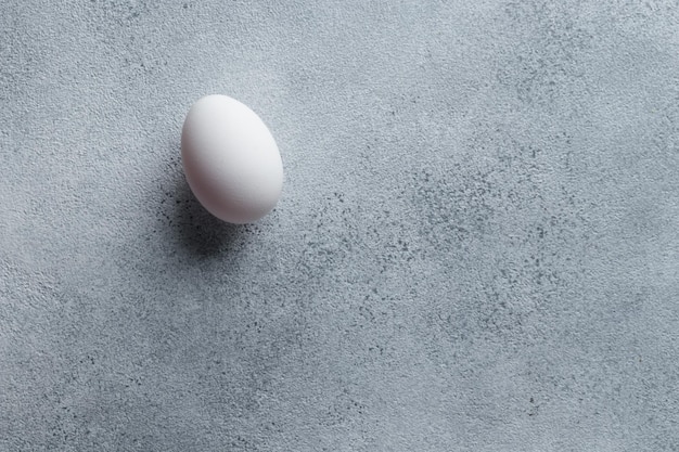 Oeuf blanc sur une vue de dessus de table en béton