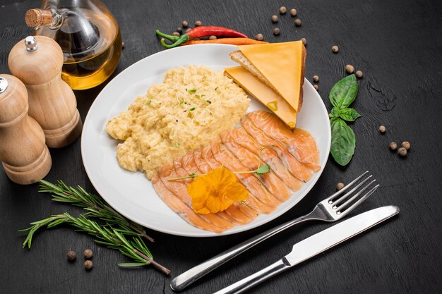 Oeuf brouillé avec sandwich au saumon et au fromage sur fond de bois