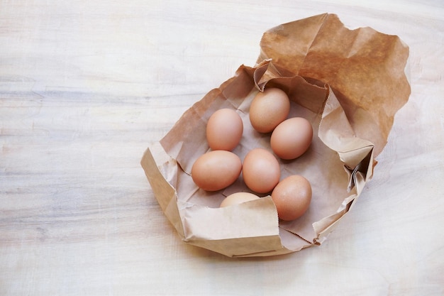 Oeuf Brun Dans Un Sac En Papier Derrière Oeufs De Poule Frais Sur Table En Bois