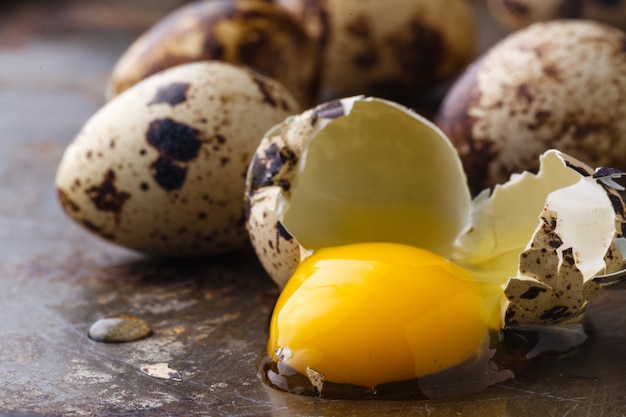 Oeuf de caille cassé sur table rustique