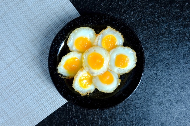 Oeuf de caille frit sur fond noir